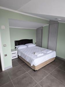 a bedroom with a large bed with white sheets at Dentist Bulent's Villas in Kusadası +2 photos