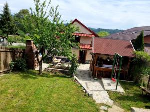 a yard with a house and a house with a tree at Pensiunea Mirela in Breaza