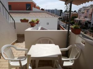 une table et des chaises sur le balcon d'un bâtiment dans l'établissement Vivenda Maravilhosa em Portimão - Bemposta Alvor, à Alvor