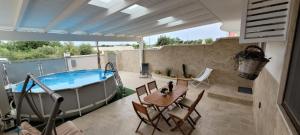 a patio with a pool and a table and chairs at The Sunflower in Lecce