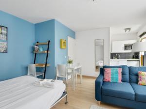 a living room with a blue couch and a table at Quiet studio between train stations and the Opera. in Lille