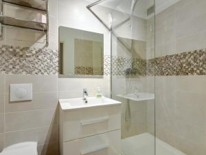 a white bathroom with a sink and a shower at Quiet studio between train stations and the Opera. in Lille