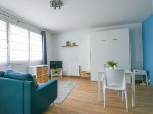 a living room with a blue couch and a table at Quiet studio between train stations and the Opera. in Lille