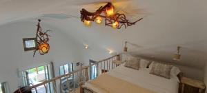 a bedroom with a bed and a chandelier at Aliori art caves in Aegiali +37 photos