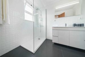 a white bathroom with a shower and a sink at Alex Apartment by Mth in Funchal +16 photos