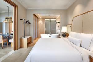a bedroom with a large bed and a bathroom at The Westin Resort, Costa Navarino in Romanu