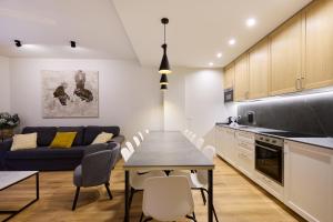 a kitchen and living room with a table and a couch at Los Balcones del Encierro - Estafeta 65 in Pamplona