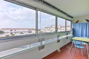 a classroom with windows and a table and chairs at L'Albatros - 50m plage - Parking in Plage-des-Demoiselles