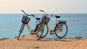 two bikes parked on the beach near the water at La Finestra sul Mare in Isola Rossa