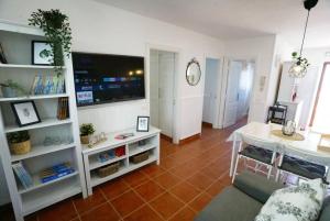 a living room with a couch and a table and a tv at Terraza, céntrico pueblo aparcamiento cerca in Icod de los Vinos