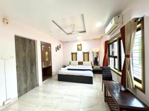 a hotel room with a bed and a table at Hotel Laxmi Residency in Lonavala