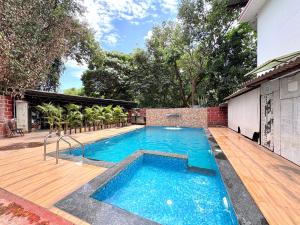 a swimming pool in a backyard with a wooden deck at Hotel Laxmi Residency in Lonavala
