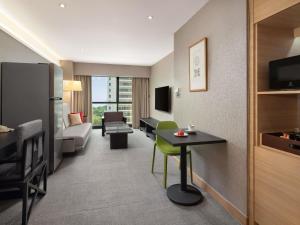 新加坡Grand Mercure Singapore Roxy的带厨房和客厅的酒店房间