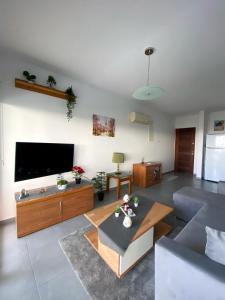 a living room with a large flat screen tv at STAY Peyia Sunset Pearl in Peyia