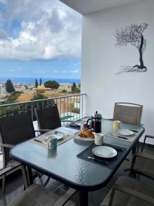 a blue table with food on top of a balcony at STAY Peyia Sunset Pearl in Peyia