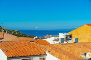 a view of roofs with the ocean in the background at Rena Bianca Magico Trilo Rosso in Santa Teresa Gallura