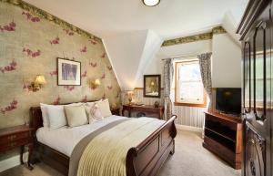 a bedroom with a large bed and a tv at Stage House Bed & Breakfast in Glenfinnan