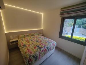 une petite chambre avec un lit et une fenêtre dans l'établissement Piso reformado a pie de playa Sa Riera Begur, à Begur