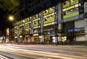 een gebouw 's nachts met verkeer ervoor bij Park City Inn & Hostel in Yonghe