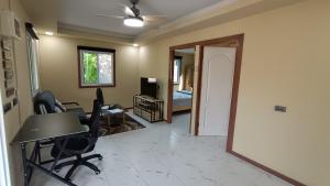 Zimmer mit einem Schreibtisch und Stühlen sowie einem Schlafzimmer. in der Unterkunft Fern lovely home with big garden in Ko Phangan