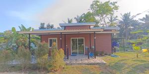 ein kleines rotes Haus in einem Garten mit Bäumen in der Unterkunft Fern lovely home with big garden in Ko Phangan