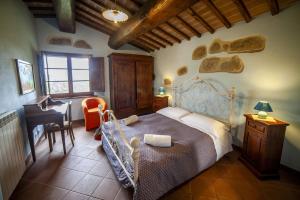 Un dormitorio con una cama y un escritorio en una habitación. en Agriturismo Podere Il Colle, en Radicondoli