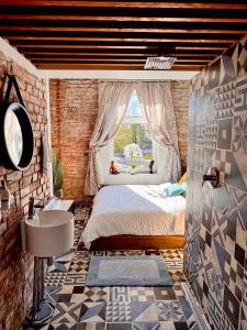 a bedroom with a bed and a sink and a window at Vibrant Downtown Studio Oasis in Liepāja