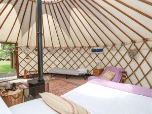 Habitación con cama y sillas en una yurta en Stardust, en Ventnor