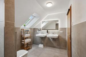 Un baño con dos lavabos y un espejo. en Das Familien Nest by ALA Living - LEGOLAND in 8min! - privater Garten & Grill, en Leipheim 35 fotos más