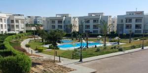 Blick auf einen Pool in einem Resort in der Unterkunft Amwaj sidi abed el rahman in Banī Ghālib