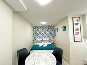 une petite pièce avec un lit et une table dans l'établissement 162 - Urban Studio in Montorgueil, à Paris