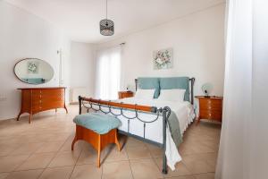 a bedroom with a bed and a table and a chair at Vista Mare Blu House in Agioi Theodoroi