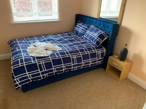Un dormitorio con una cama azul con una manta azul y blanca en 2 bed 2 bath right next to Park located for access to West end and GTW, en Croydon