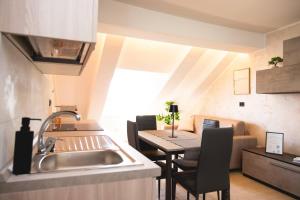 a kitchen with a sink and a table with chairs at Piazza Vittorio Central Suite in Turin