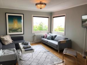 a living room with a couch and a table at West coast villa with stunning ocean view ! in Hovenäset