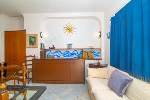 a living room with blue curtains and a couch at Vacanze nel Blu Rena Bianca in Santa Teresa Gallura