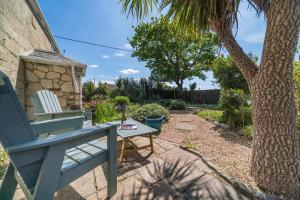 Una silla azul y una mesa junto a una palmera. en Matchells, en Freshwater
