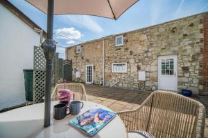 Una mesa con sillas y una sombrilla en un patio. en Matchells, en Freshwater 21 fotos más