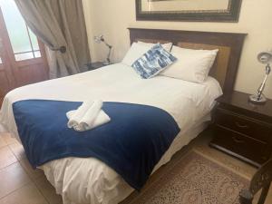 a bedroom with a bed with two towels on it at Tucker House B&B in Kimberley
