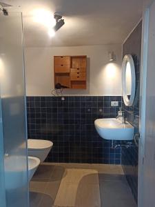 a bathroom with two sinks and a toilet at Torrione Apartment in Panzano