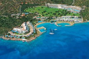 an aerial view of a resort with boats in the water at Porto Elounda Golf & Spa Resort, Six Senses Spa in Elounda
