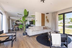 a living room with a couch and a table at Harderwold Villa Resort XL in Zeewolde