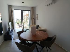 a living room with a wooden table and chairs at Sea view Penthouse Universal Residences in Paphos