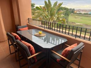 a balcony with a table and chairs and a window at Casa Serenidad in Torre-Pacheco