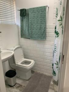 a bathroom with a toilet and a green towel at Just a Bed parking on street in Stellenbosch +10 photos