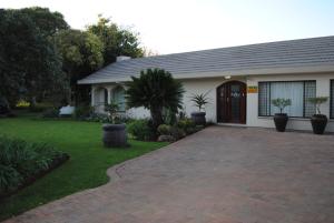 a house with a driveway in front of it at Amaris Guesthouse in Lichtenburg