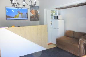 un soggiorno con divano e frigorifero bianco di Fargon Guest House a Polokwane