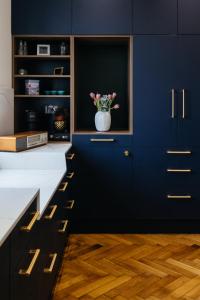 a blue kitchen with a vase with flowers in it at Peacock Apartments Split in Split +59 photos