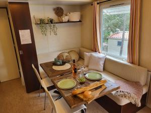 stolik w małym domku z oknem w obiekcie Mobilehome Leï Suves Côte d'Azur w mieście Roquebrune-sur Argens