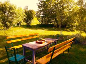 a wooden table with two chairs and a picnic table at EcoFit Povlen in Valjevo